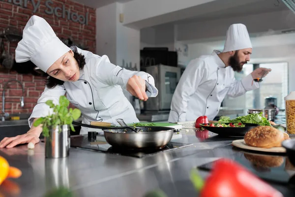 Fine dining restaurant head chef seasoning gourmet dish and adding chopped fresh herbs and greens. —  Fotos de Stock