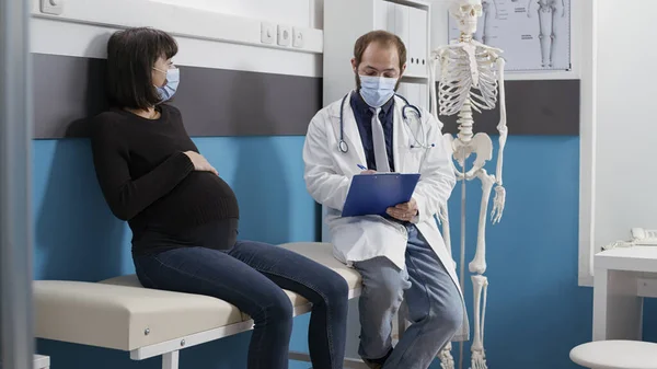 Médico e mulher grávida fazendo consulta no gabinete — Fotografia de Stock