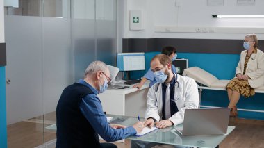 Sıhhiye ile olan randevusunda kıdemli hasta kontrol kağıtlarını imzalıyor