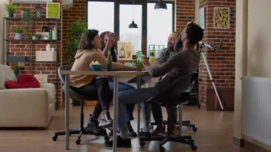 Erkekler ve kadınlar oturma odasında alnında kağıt oynuyorlar.