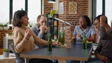 Ahşap bloklar ile kule oyunu oynayan neşeli insanlar