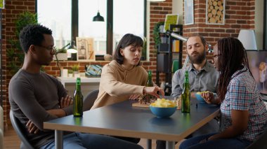 Genç insanlar apartmanda masa oyunu oynuyorlar.