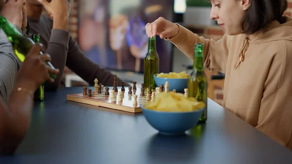 Focused woman playing strategic board games with friends — 스톡 사진