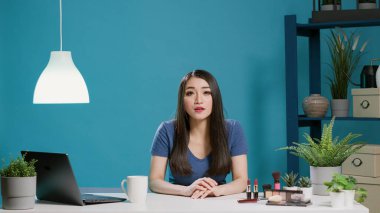 Güzellik blogcusu kamera önünde makyaj ürünlerinden bahsediyor.