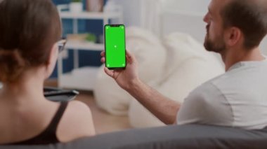 Çevreci vlog içeriği hakkında konuşan çift dikey akıllı telefon tutuyor