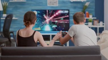 Çift, büyük ekran televizyonun önünde adamın online oyunu kaybetmesi üzerine tartışıyor.