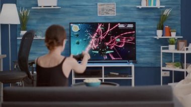 Elinde kablosuz kontrol cihazı olan genç bir kadın online oyunu kaybettiği için hayal kırıklığına uğradı.