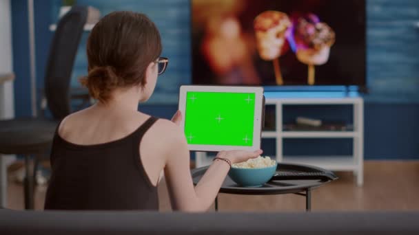 Vista posteriore della giovane donna con tablet digitale con schermo verde che guarda i contenuti video dei social media — Video Stock