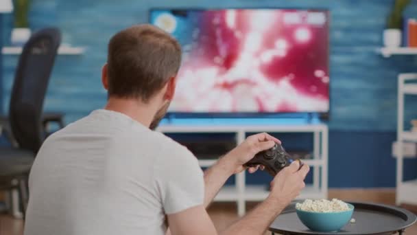 Closeup of man holding controller disappointed because losing online first person shooter game — Stockvideo