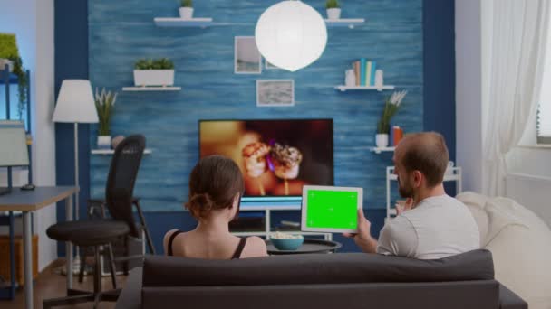 Static video of couple looking at digital tablet with green screen watching online video content — Stockvideo