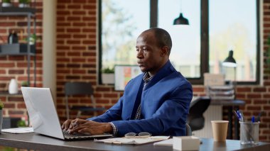 Yönetici asistanı ofisteki iş projesinde çalışmak için dizüstü bilgisayarda istatistik oluşturuyor. Çevrimiçi bilgiyle yeni bir strateji planlayan ve internet uygulaması üzerine notlar alan genç işadamı.