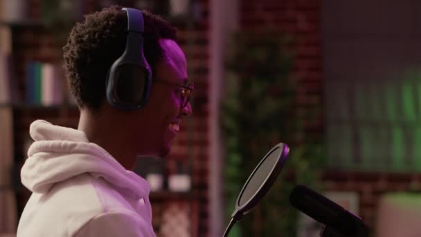 Closeup of african american online radio host during interview listening and smiling sitting at desk — Video