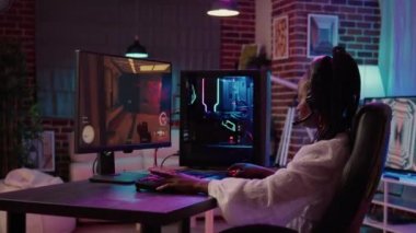 Afrika kökenli Amerikalı oyun kızı oyun bilgisayar kurulumu ile oyun oynayarak zaman geçiriyor.