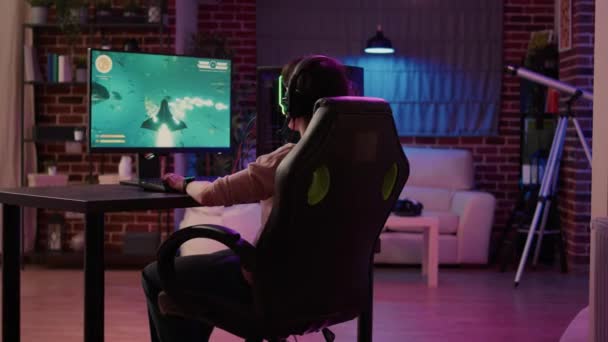 Over shoulder view of gamer girl relaxing playing rpg action game on professional pc setup — Video