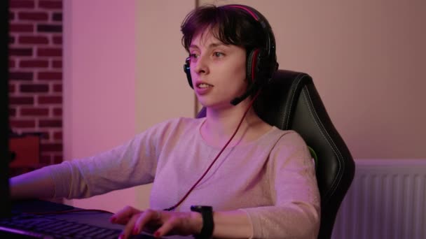 Zbliżenie kobiety z zestawu słuchawkowego gry multiplayer first person shooter streaming gameplay — Wideo stockowe