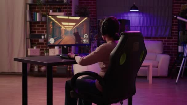 Gamer girl en utilisant pc gaming setup relaxant jouer multijoueur jeu d'action en ligne parler en utilisant casque — Video