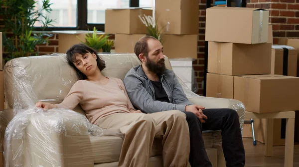 Married couple feeling tired after unpacking furniture and moving in — Stock Photo, Image