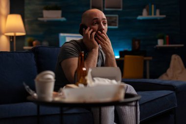 Depresyondaki şok olmuş adam telefon konuşmasını dinliyor.