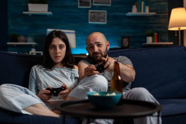 POV of young couple using console to play videogames challenge