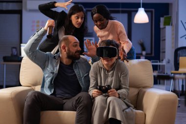 Video oyunu oynayan çok ırklı bir grup arkadaş.