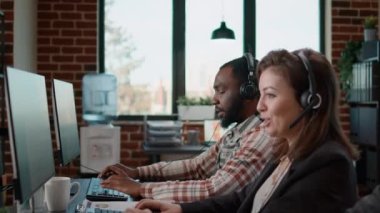 Yardım hattı ajanları çağrı merkezinde kulaklıkla müşterilerle konuşuyor.