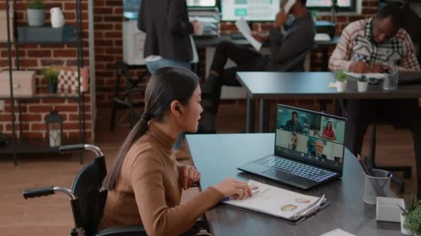 Женщина, присутствующая на видеоконференции на ноутбуке с удобным для инвалидов офисом — стоковое видео