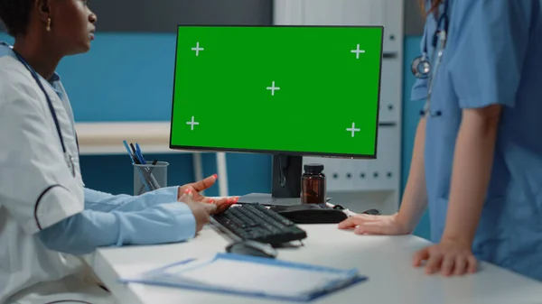 Großaufnahme eines Computers mit horizontalem grünen Bildschirm auf dem Schreibtisch — Stockfoto