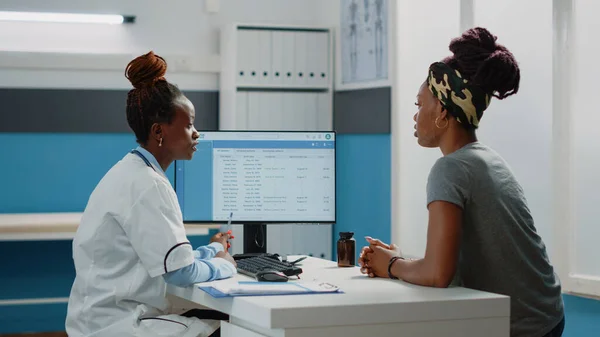 Afroamerikanische Ärztin und Frau blicken auf Computerbildschirm — Stockfoto