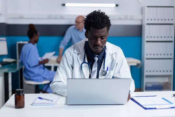 Practitioner expert using laptop in healthcare facility cabinet — Fotografia de Stock
