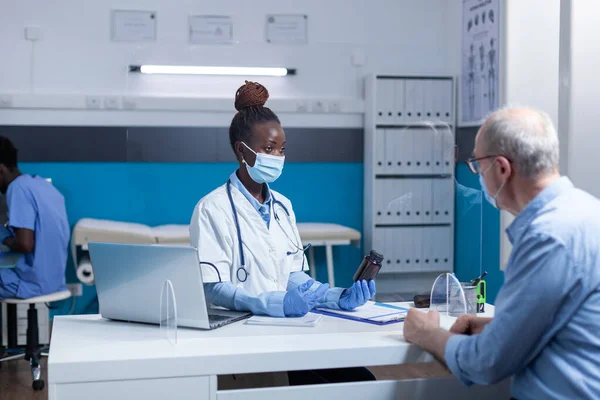 African american physician expert holding vial of covid medicine — Fotografia de Stock