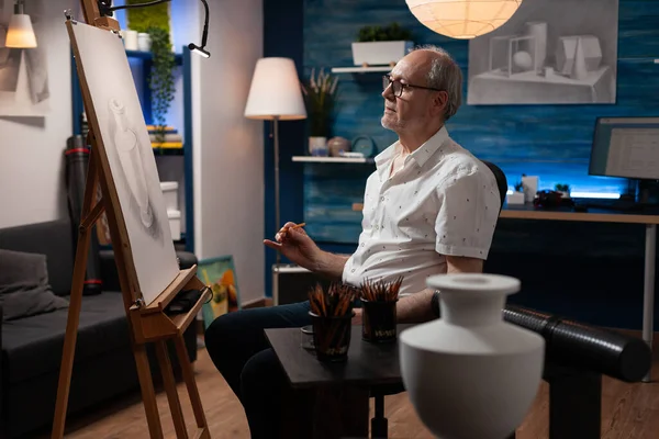 鉛筆画を持つ引退した芸術家が座って夜の進歩を賞賛 — ストック写真