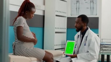 Tablette yeşil ekran şablonu gösteren erkek doktor
