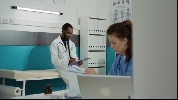 Προσωπογραφία του ιατρού γενικής ιατρικής που σημειώνει στο ιατρικό γραφείο — Αρχείο Βίντεο