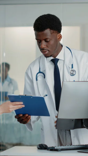 Homem trabalhando como médico usando computador e documentos — Fotografia de Stock