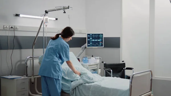 Läkarassistent förbereder sjukhussäng för patienten — Stockfoto