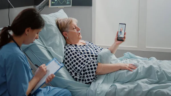 Donna malata che utilizza la videochiamata su smartphone per appuntamento — Foto Stock
