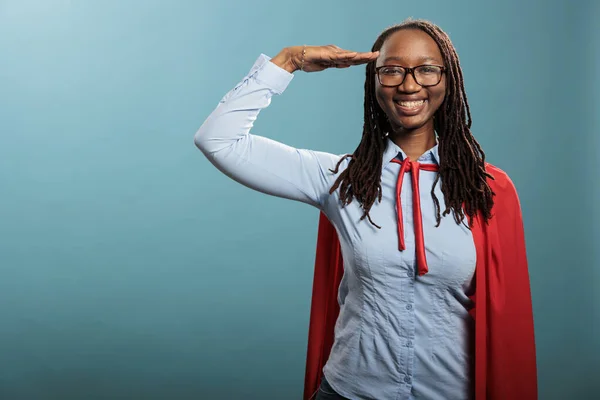 Patriotic justice defender saluting with respect while standing on blue background while smiling at camera. — Stok fotoğraf