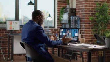 Businessman talking to manager on online teleconference call