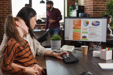 Küçük kızı kucağında otururken finans danışmanı yönetim ve geliştirme sunum çizelgesini inceliyor..