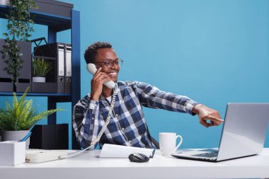 Marketing company happy joyful african american office worker on landline call with accountant