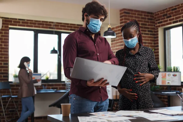 Coronavirus 'a karşı maske takan çok çeşitli etnik ofis çalışanları finansal verileri analiz ediyorlar. — Stok fotoğraf