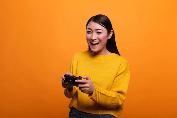 Beautiful cheerful excited young adult woman playing video games wtih modern controller — Stockfoto