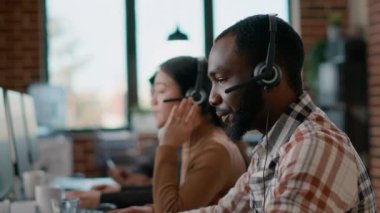 Çağrı merkezinde telesekreter cevap veren erkek işçi.