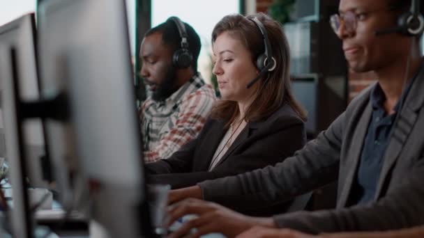 Young woman using audio headset and computer at call center — Stok video