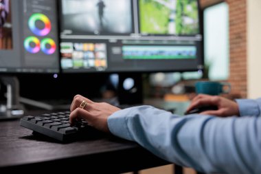 Dijital video düzenleyicisinin, film çekimleri üzerinde çalışırken çoklu monitör çalışma masasında otururken yakın plan görüntüsü.