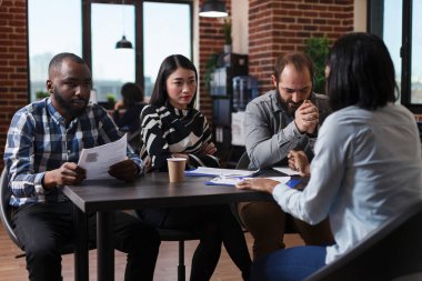 Ofiste oturan çok ırklı işverenler iş başvurusunda bulunanlarla maaş ve çalışma politikaları hakkında tartışırken,.