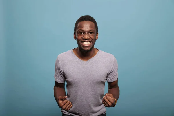 Hombre afroamericano celebrando logro con los puños cerrados — Foto de Stock