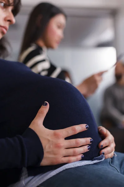Close up of pregnant manager applicant holding hands on belly bump — Fotografia de Stock