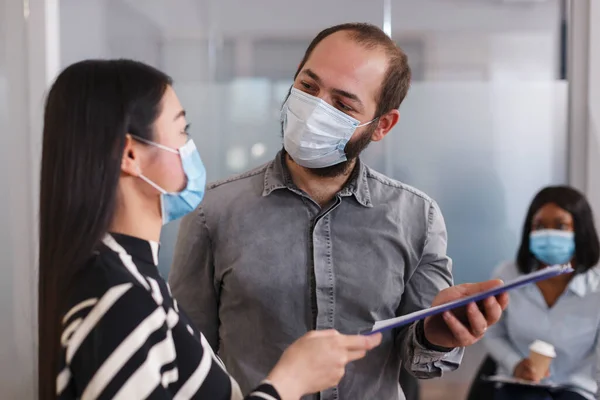 Positive and confident employer wearing protective mask while talking with job applicant about CV resume. — 스톡 사진