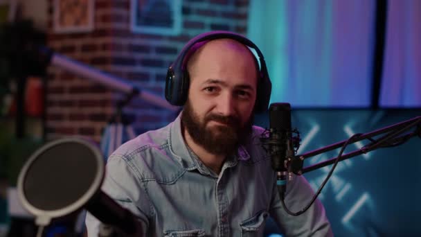 Closeup portrait of man recording online podcast with professional microphone smiling at camera — Stockvideo
